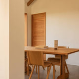 Rectangular oak Puffin Dining Table with Ready Dining Chairs and a Hashira Portable Table Lamp in a minimalist room.