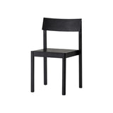 Mauro Dining Chair in black oak with a minimalist wooden frame and curved backrest, shown from a three-quarter angle.
