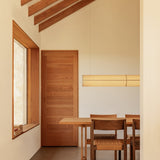 Rectangular Puffin Dining Table and Mauro Dining Chairs with papercord seats beneath a Hashira Linear Pendant Lamp.