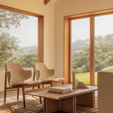 Two Penguin Wooden Lounge Chairs in Logan Fossil and a Conrad Lounge Table on a brown Tile Rug with a scenic backdrop.