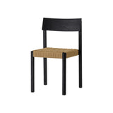 Mauro Dining Chair in black oak with a handwoven natural paper cord seat, shown from a three-quarter angle.