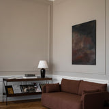 Brown Offset Sofa in a classic living room with grey walls, herringbone floor, a console table and abstract art.