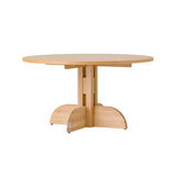 Round Puffin Dining Table in natural oak with a sculptural solid wood base, isolated on a plain white background.