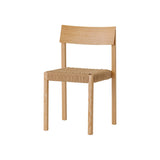 Mauro Dining Chair in natural oak with a handwoven papercord seat, showcasing its minimalist wood frame from an angle.