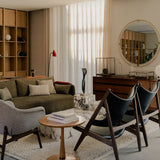 A stylish living room with the Offset Sofa, Harbour Lounge Chair, Knitting Chairs, Plinth coffee table, and Nimbus Mirror.