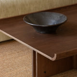 Conrad Lounge Table in dark stained oak veneer with a decorative bowl on top, shown in a styled interior setting.